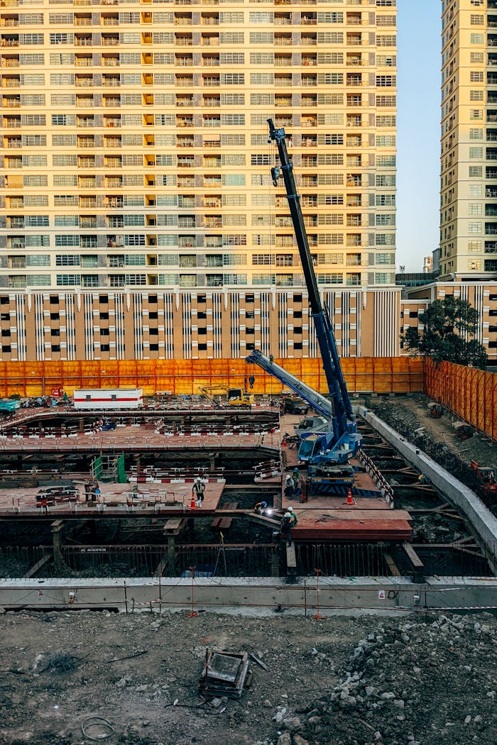 A vibrant city construction site with towering high-rises in the background.