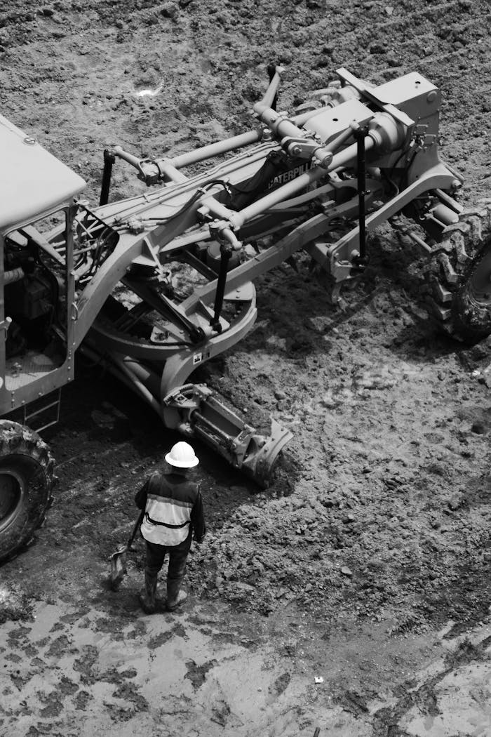 Black and white image of a construction worker with machinery in Ciudad de México, México.