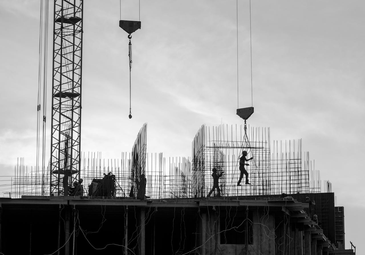 Silhouette of workers on a construction site with cranes and scaffolding in Saint Petersburg.